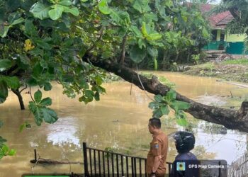Kabid SD Dindikbud Kabupaten Serang, Abidin Nasyar, saat meninjau sekolah yang dekat sungai, Rabu (14/1/2026). (SIDIK/SATELITNEWS.COM)