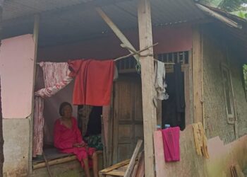 DUDUK : Seorang nenek miskin di Kabupaten Pandeglang duduk didepan gubuk reyot miliknya. (ISTIMEWA)