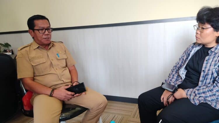 Kepala Bidang (Kabid) UMKM Diskoumperindag Kabupaten Serang, Yosi Ekamarsa, saat berbincang dengan warga di kantornya. (ISTIMEWA)