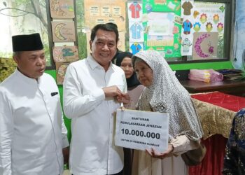 ZAKAT PROFESI: Bupati Tangerang secara simbolis menyerahkan bantuan zakat profesi kepada salah satu penerima manfaat yang berprofesi sebagai petugas pemulasaran jenazah, Rabu (4/3/2026). (ALFIAN/SATELIT NEWS)