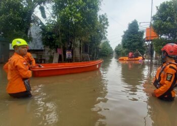 MEMBAWA PERAHU KARET : Personel BPBD Provinsi Banten membawa perahu karet dilokasi banjir untuk membantu mengevakuasi masyarakat yang terkena dampak. (ISTIMEWA)