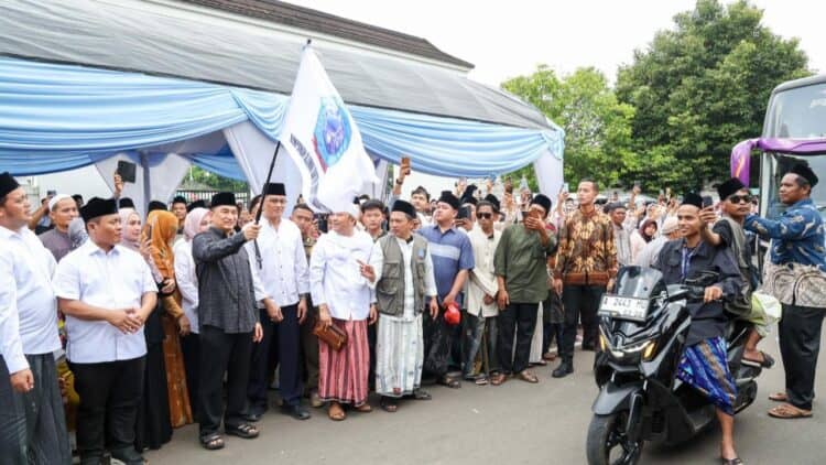 MELEPAS SANTRI : Wakil Gubernur Banten Achmad Dimyati Natakusumah (memegang bendera) bersama tokoh agama dan pengurus HIMASAL Provinsi Banten melepas ribuan santri menuju Ponpes Lirboyo. (ISTIMEWA)