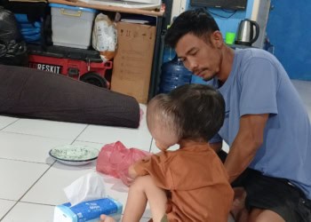 Farhan, balita penderita tumor ganas asal Desa Banyuasih, Kecamatan Cigeulis, Kabupaten Pandeglang, bersama ayahnya berada di rumah singgah FBn, Kota Serang, Selasa (7/4/2026) malam. (ISTIMEWA)