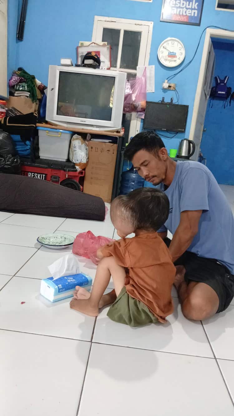 Farhan, balita penderita tumor ganas asal Desa Banyuasih, Kecamatan Cigeulis, Kabupaten Pandeglang, bersama ayahnya berada di rumah singgah FBn, Kota Serang, Selasa (7/4/2026) malam. (ISTIMEWA)