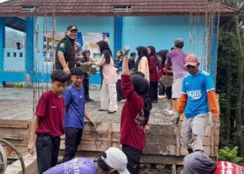 BERGOTONG ROYONG - Camat Pulosari Juhanes Waluyo, bersama para pelajar dan masyarakat, bergotong royong mengecor bangunan sekolah. (ISTIMEWA)