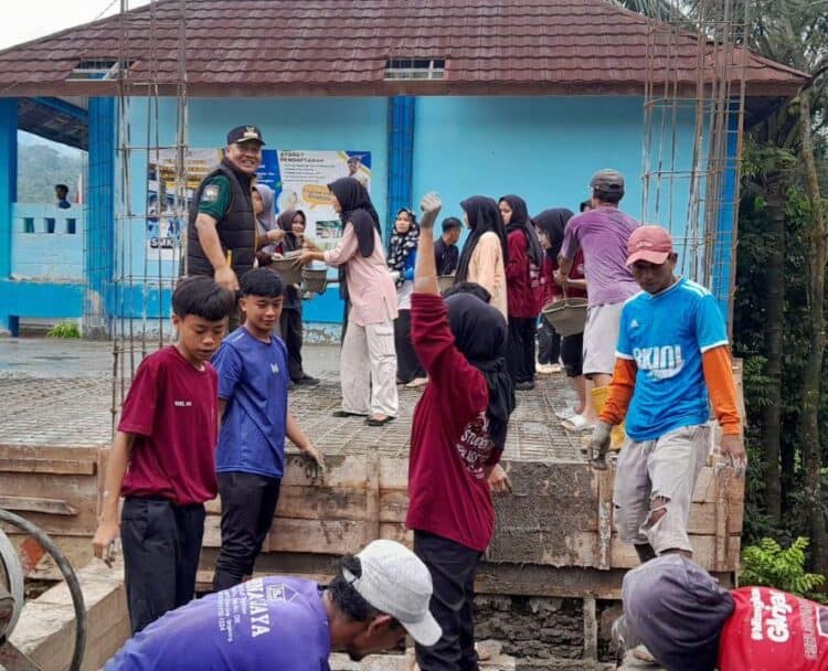 BERGOTONG ROYONG - Camat Pulosari Juhanes Waluyo, bersama para pelajar dan masyarakat, bergotong royong mengecor bangunan sekolah. (ISTIMEWA)
