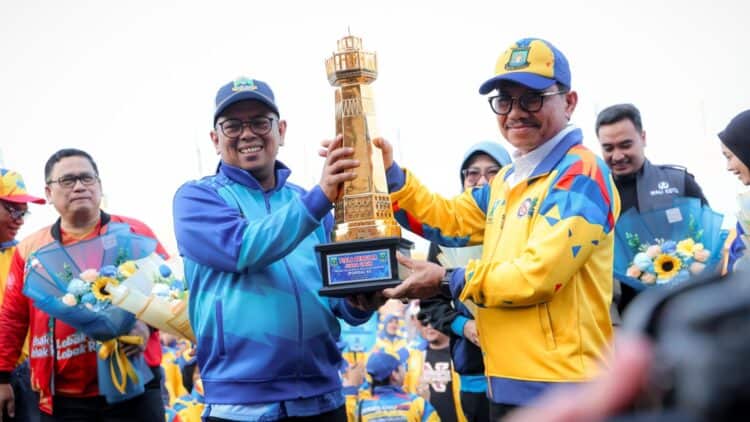 MEMBERIKAN TROFI : Gubernur Banten Andra Soni (kiri) memberikan trofi kepada juara umum Popda XII tahun 2026. (ISTIMEWA)