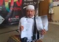 MENUNJUKKAN SURAT : Seorang warga Pandeglang yang dijanjikan mendapat pembangunan RTLH menunjukkan surat rencana pembangunan kepada wartawan di Pokja Wartawan Provinsi Banten, Senin (13/7/2026). (ISTIMEWA)