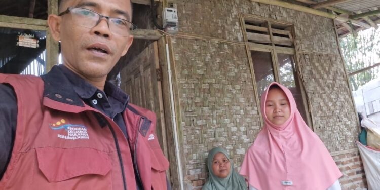 BERKUNJUNG -- Pendamping sosial PKH Kecamatan Cikeusal, Marpindo Desra (kiri), saat berkunjung ke rumah Marni. (ISTIMEWA)